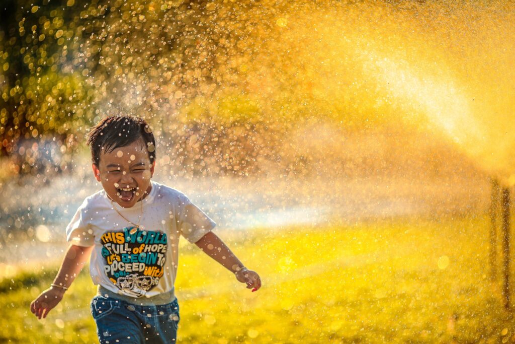 Kid playing in sprinkler